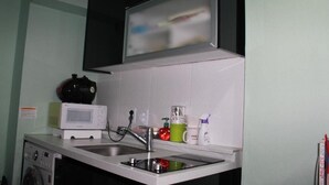 A kitchen with a microwave, sink, and a dish rack. - Mk Liberty House (Seoul)