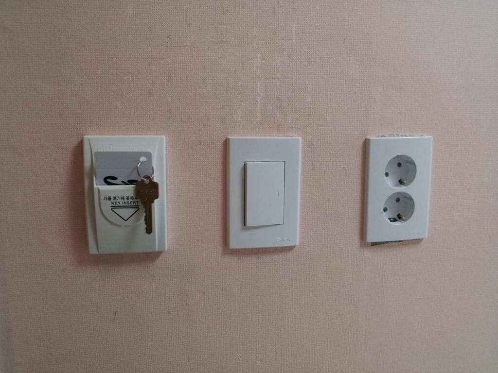 Drei Wandsteckdosen an einer strukturierten Wand.