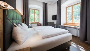 Ein modernes Hotelzimmer mit einem großen Bett, einem Schreibtisch und einem Fernseher.