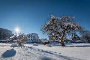 A snow-covered landscape with a large building, possibly a hotel, in the background.