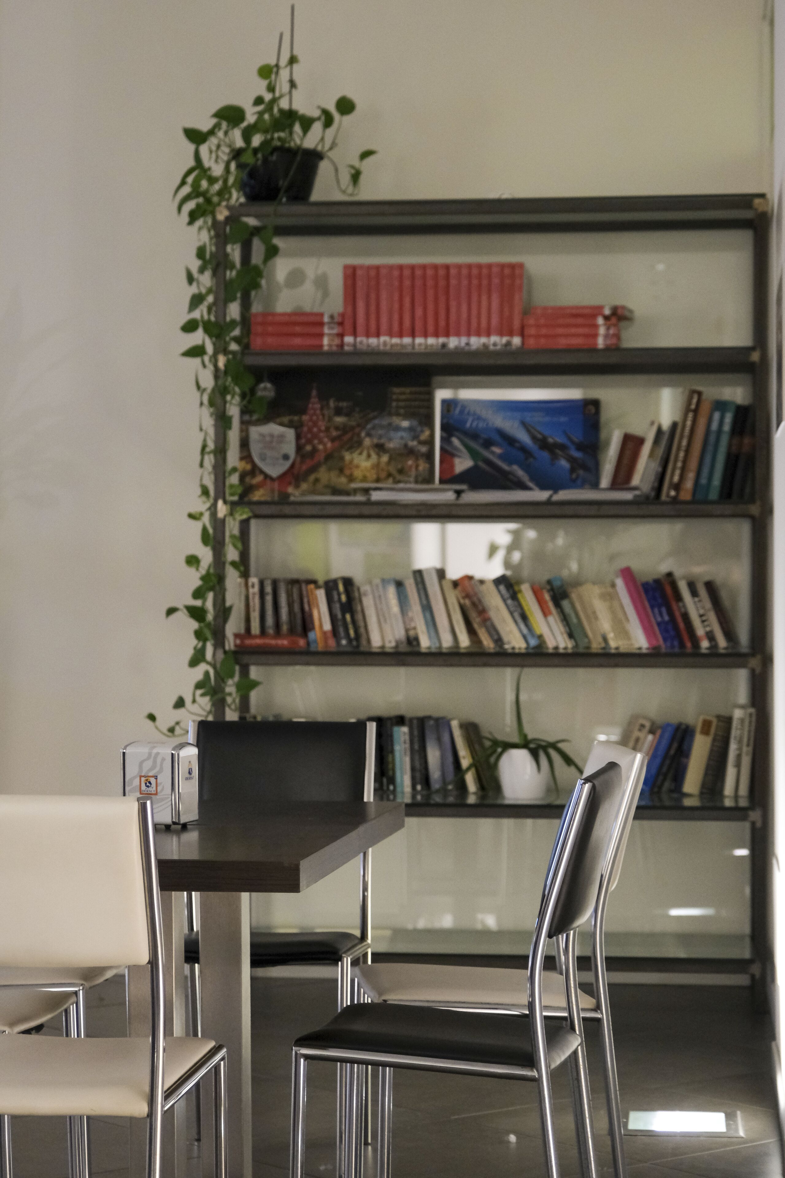 A modern library with bookshelves, a table, and chairs.