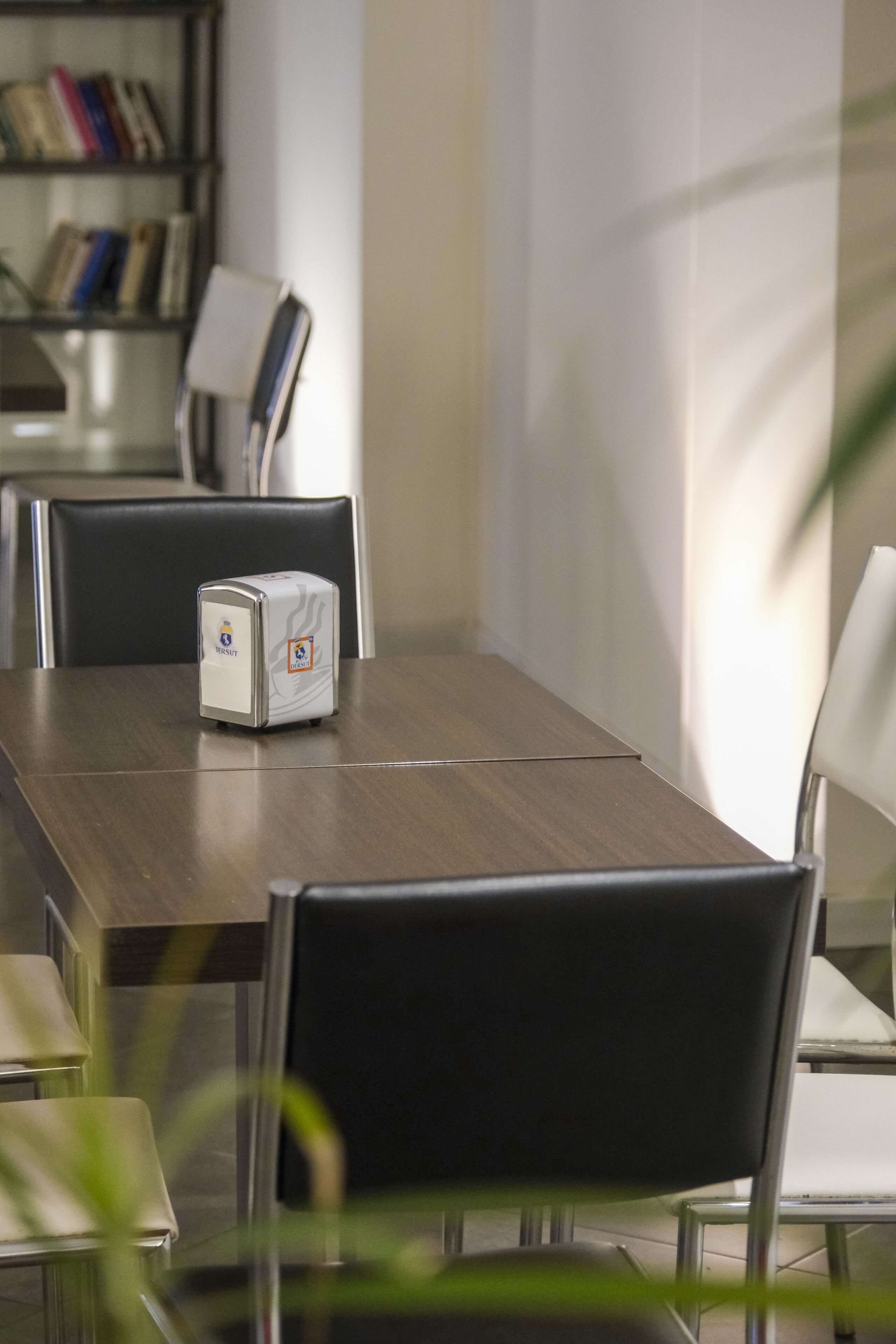 Une salle de conférence équipée d’une table en bois, d’un tableau blanc et d’un projecteur.
