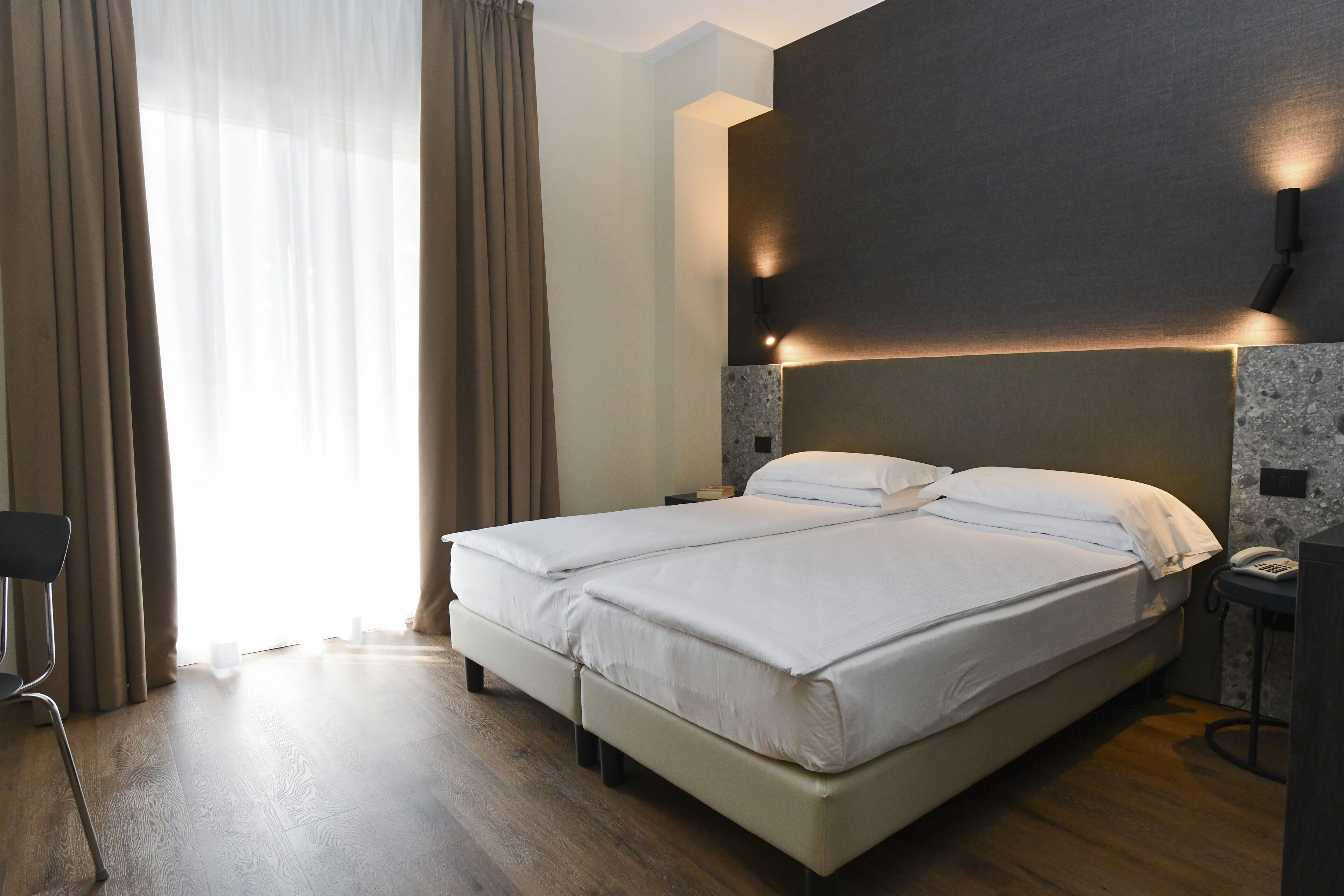 Una habitación de hotel con cama, escritorio y silla.