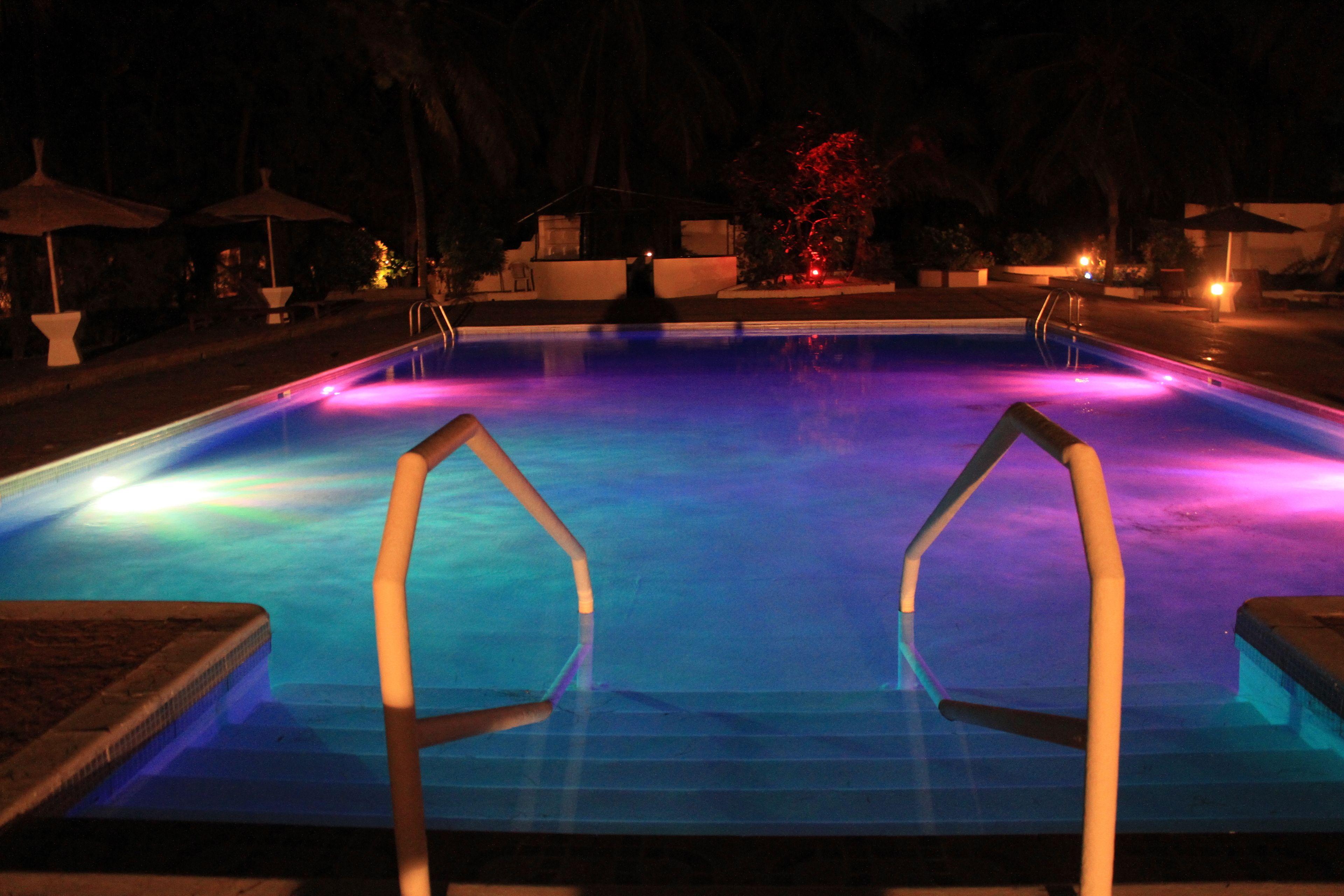 A swimming pool at night with illuminated edges and a clear view of the pool's edge.