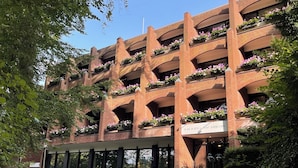 A multi-story building with a brick facade, balconies with flower boxes, and a sign indicating it is a hotel. - Das Hotel Ostseeblick (Luetjenburg)