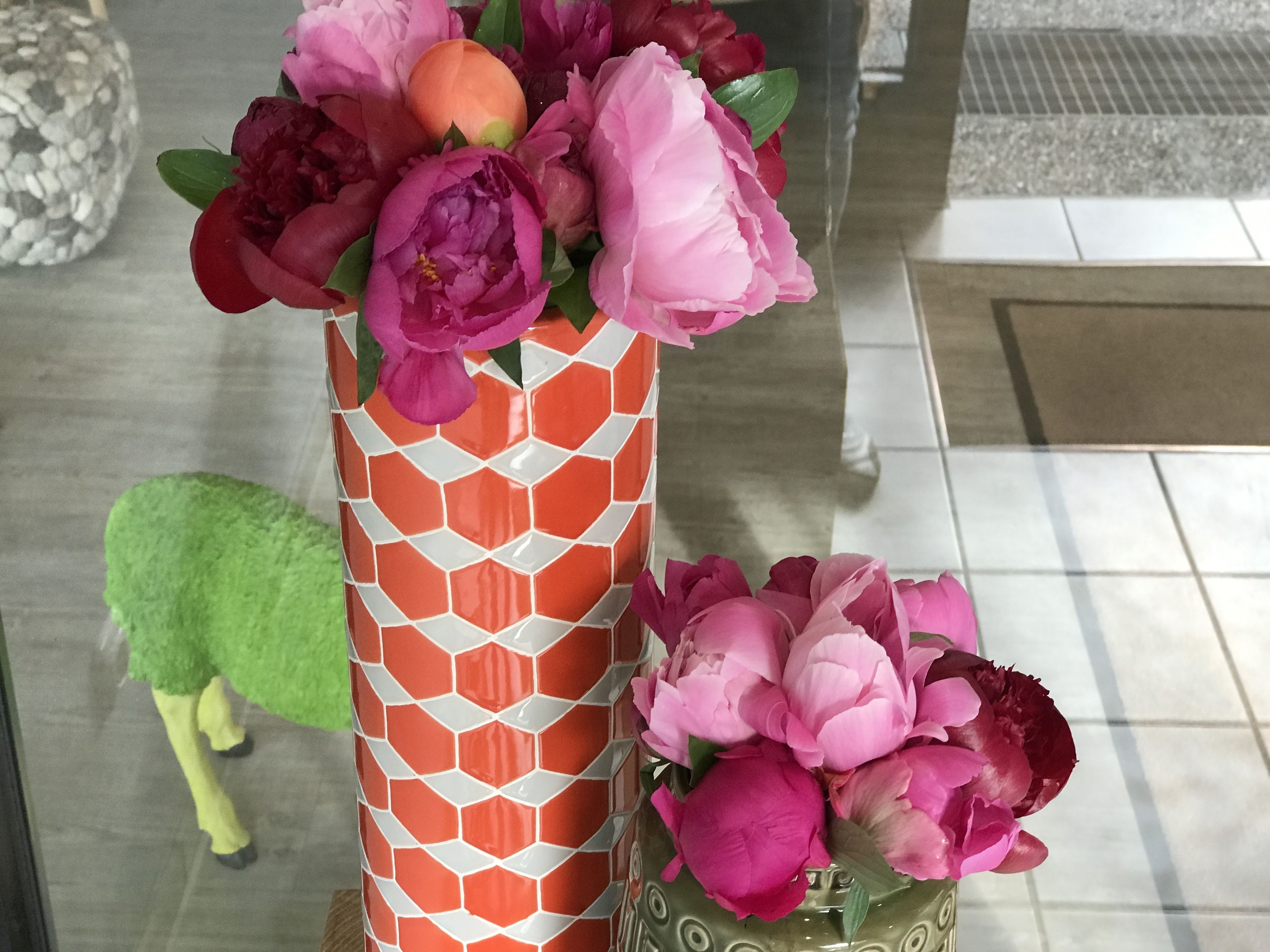 En vas med ett geometriskt mönster och rosa blommor.