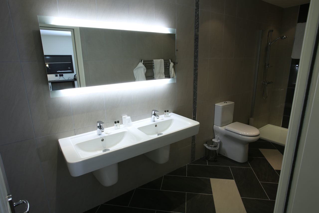 Ein modernes Badezimmer mit Waschbecken, Toilette und Dusche.