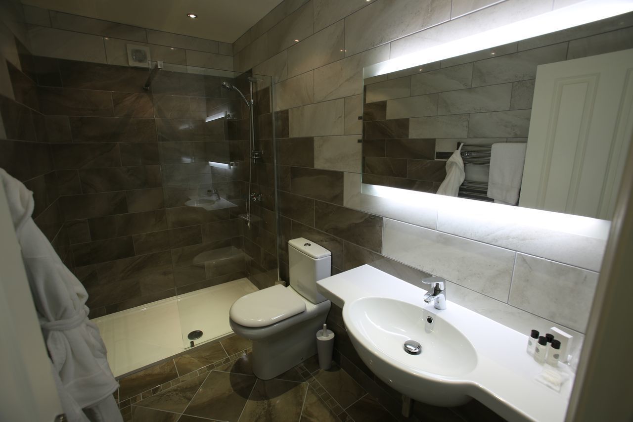 Un bagno moderno con cabina doccia in vetro, toilette e lavandino.