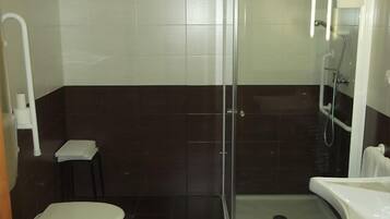 Une salle de bain comprenant des toilettes, une douche et un lavabo.
