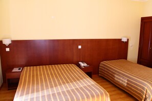 A hotel room with a large bed, a bedside table with a phone, and a nightstand. - Hotel Minho Belo (Vila Nova de Cerveira)