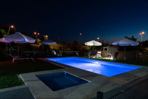 A rectangular swimming pool with a blue interior, surrounded by a concrete deck. There are lounge chairs and umbrellas around the pool area. - Hotel Minho Belo (Vila Nova de Cerveira)