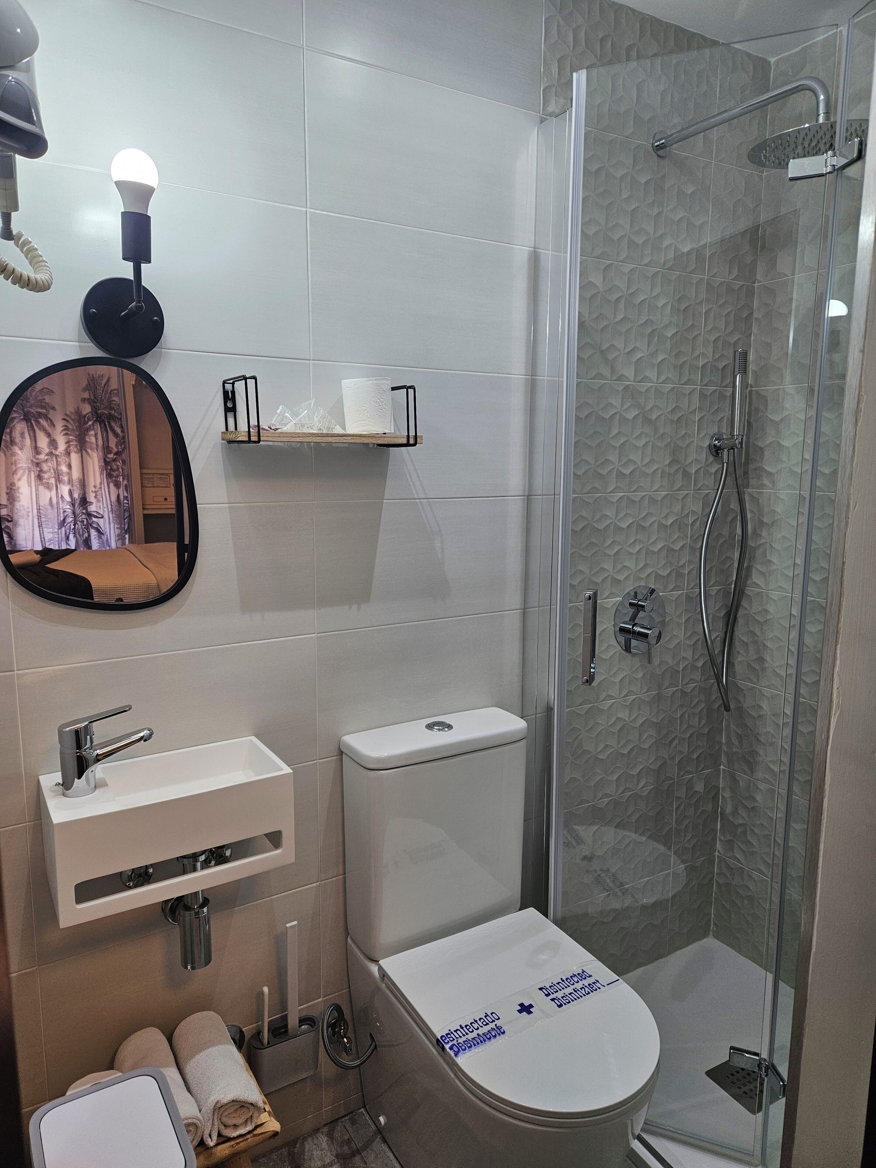 A modern bathroom with a toilet, sink, and shower.