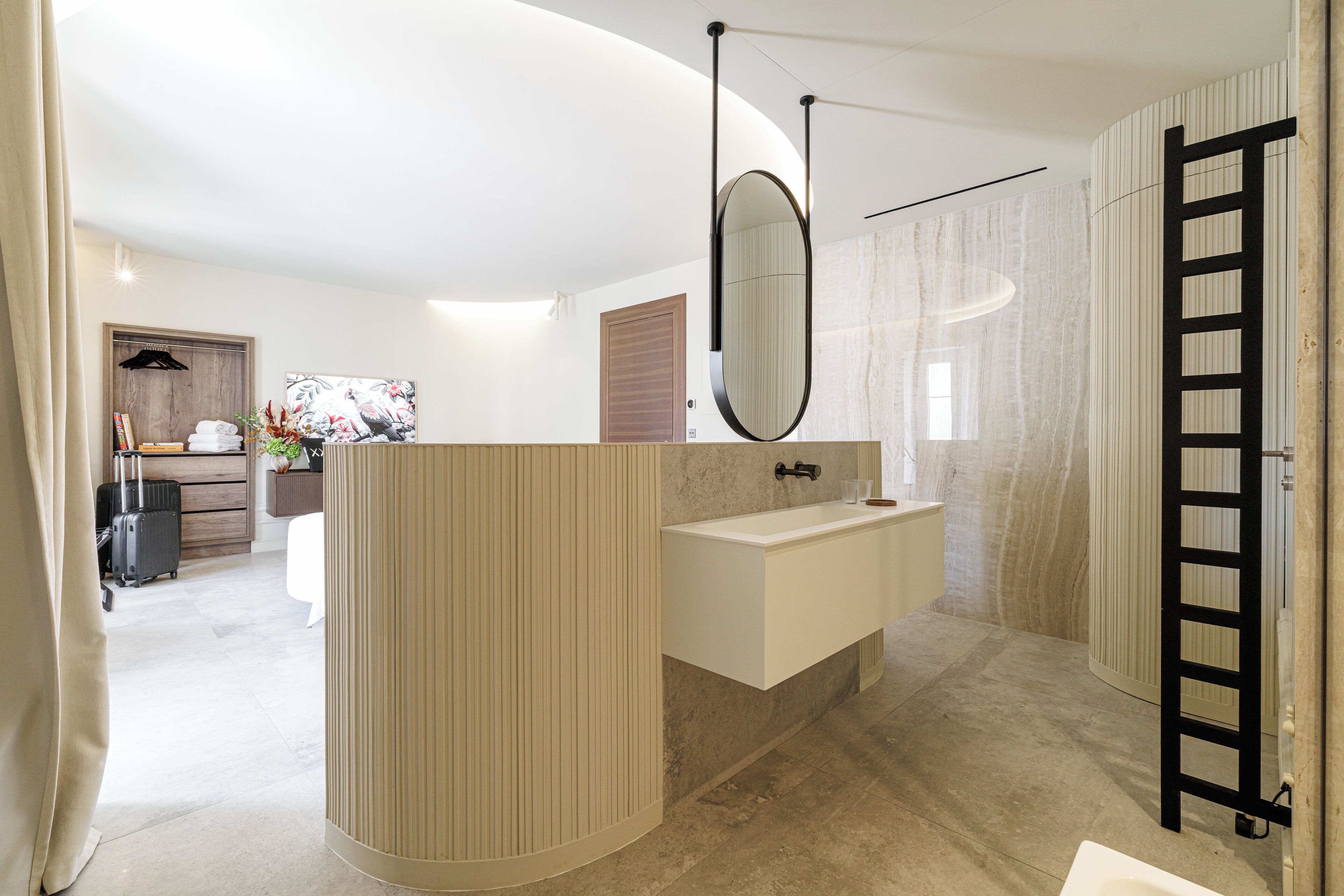 Un bagno moderno con un mobile da bagno curvo, uno specchio grande e un porta asciugamani.