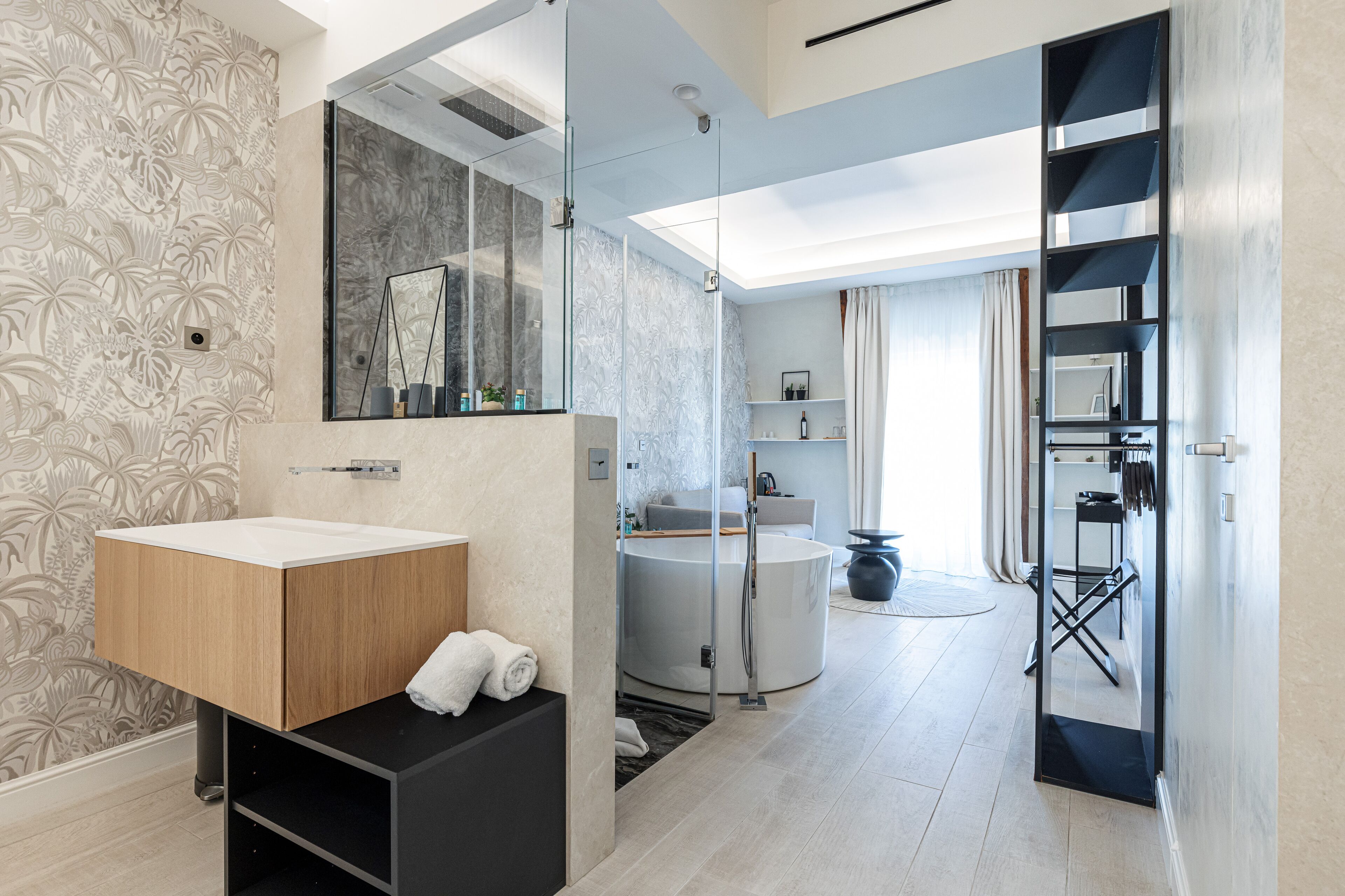 A modern bathroom with a wooden vanity, a glass shower enclosure, and a built-in bathtub.