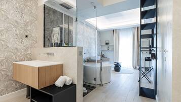 A modern bathroom with a wooden vanity, a glass shower enclosure, and a built-in bathtub.