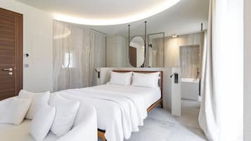 Une chambre moderne avec un grand lit, une table de chevet, un miroir et une salle de bain avec une baignoire.