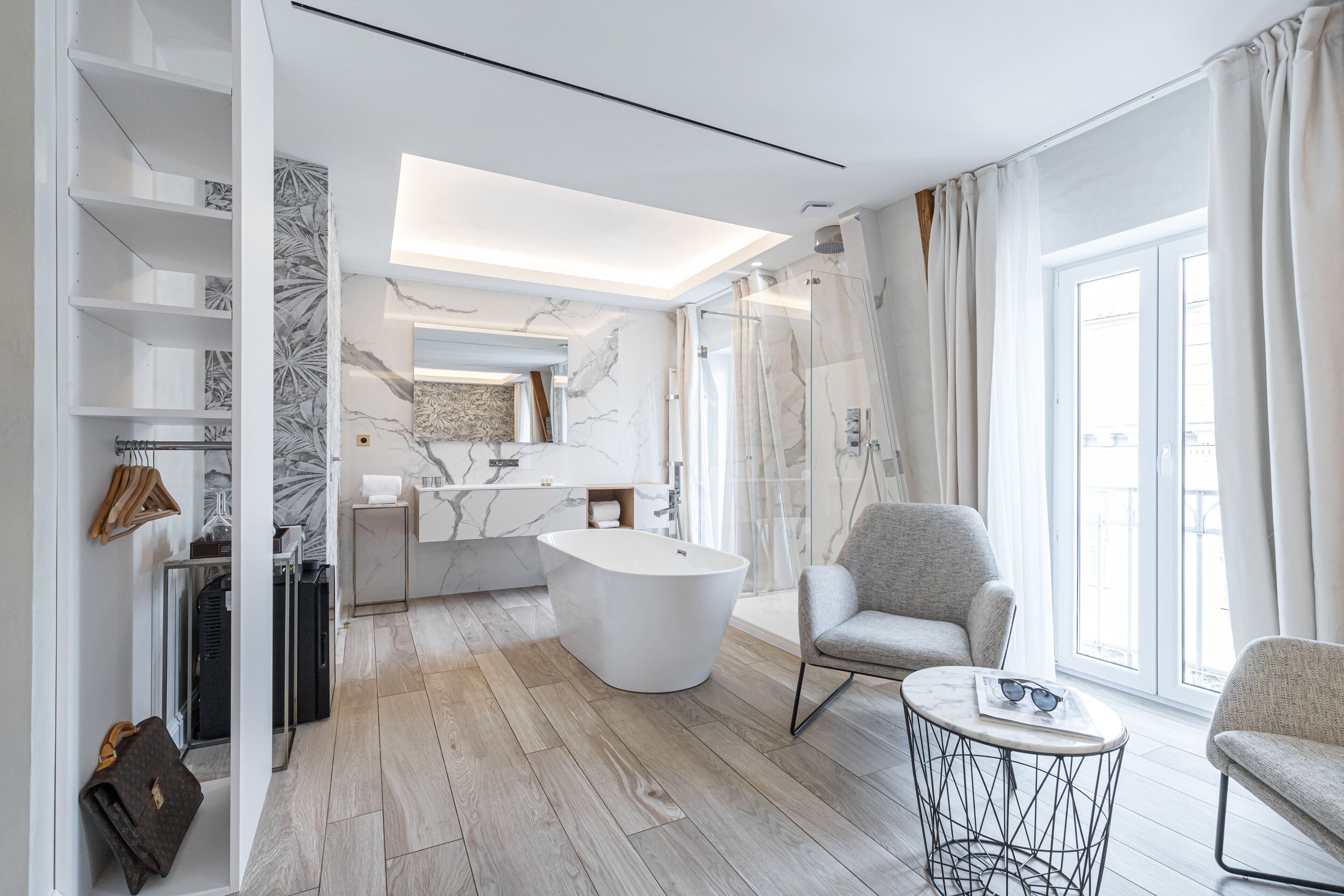 A modern bathroom with a freestanding bathtub, a vanity with a marble countertop, and a shower area with glass doors.