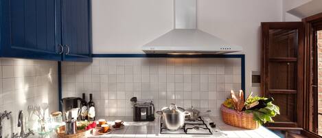 A kitchen with a stove, toaster, and various kitchen items on the counter.
