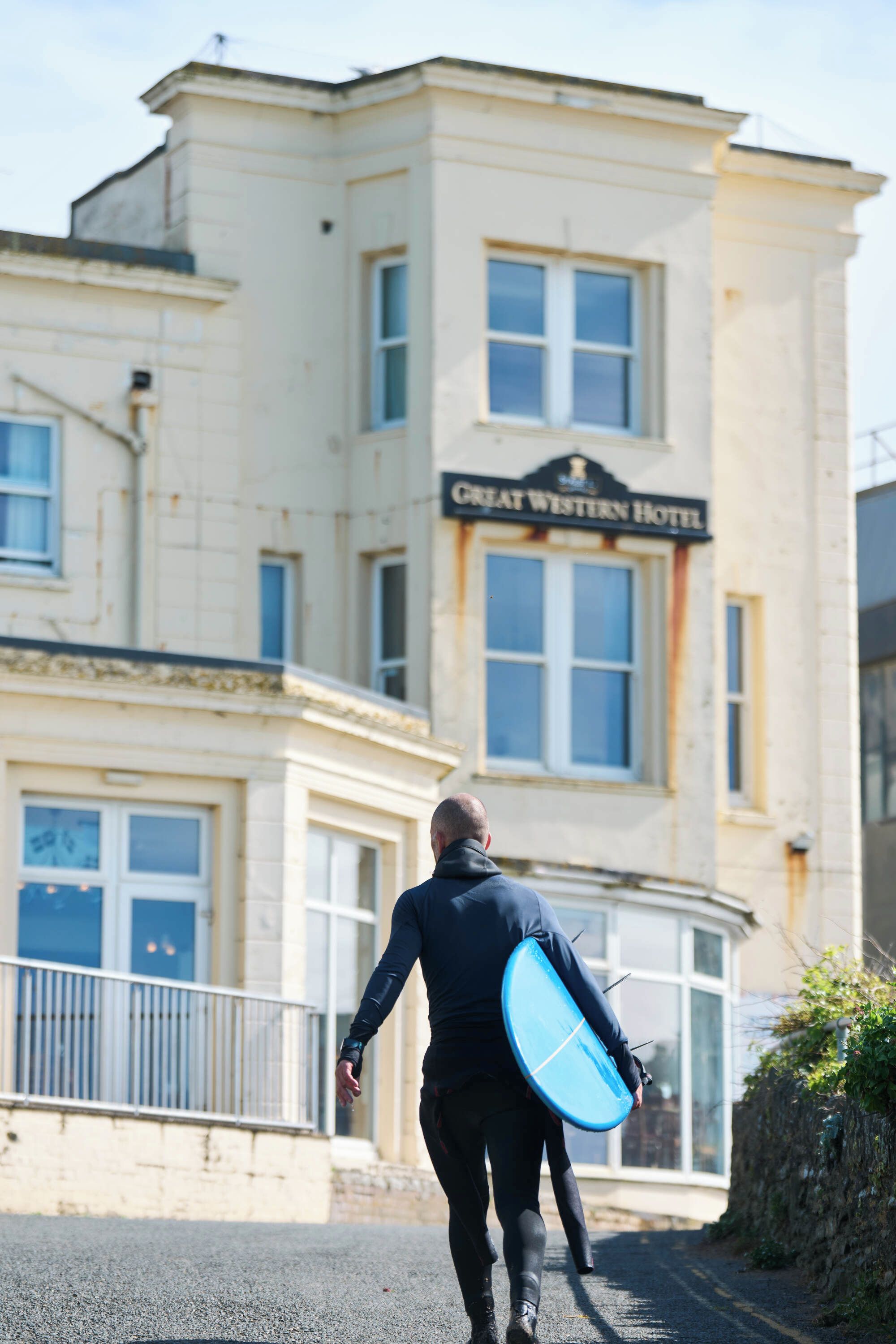 A man walking towards a building labeled 'Great Western Hotel.'