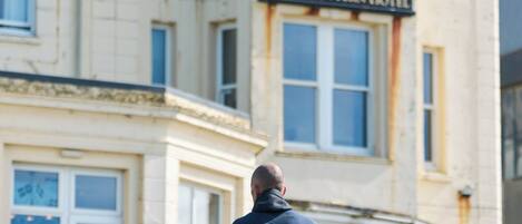 A man walking towards a building labeled 'Great Western Hotel.'