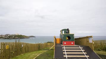 Kids can play on the green and red play structure overlooking the sea.