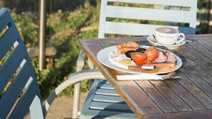 A table with a plate of food and a cup, overlooking a river and greenery. - Great Western Hotel (Newquay)