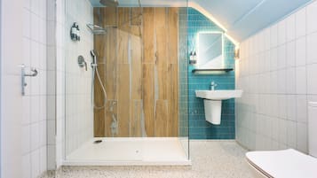 A modern bathroom with a shower, toilet, and sink.