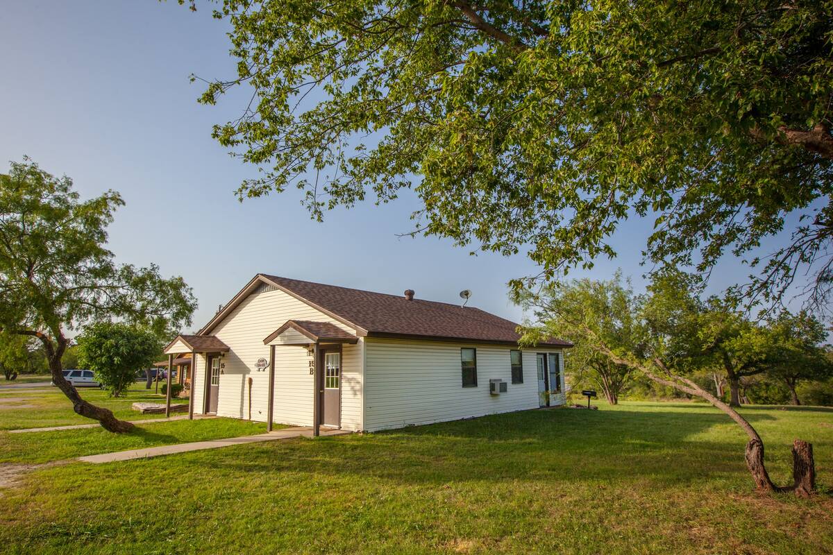A single-story house with a sloped roof, a front porch, and a small front yard.