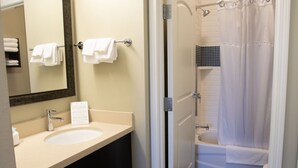 A bathroom with a sink, mirror, and bathtub. - Staybridge Suites Rochester - Commerce Dr NW by IHG (Rochester)