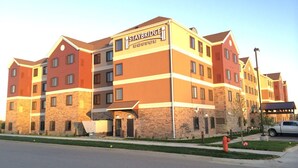 A multi-story Staybridge Suites building with a stone facade and multiple windows. - Staybridge Suites Rochester - Commerce Dr NW by IHG (Rochester)