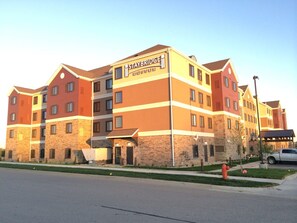 A multi-story Staybridge Suites building with a stone facade and multiple windows. - Staybridge Suites Rochester - Commerce Dr NW by IHG (Rochester)