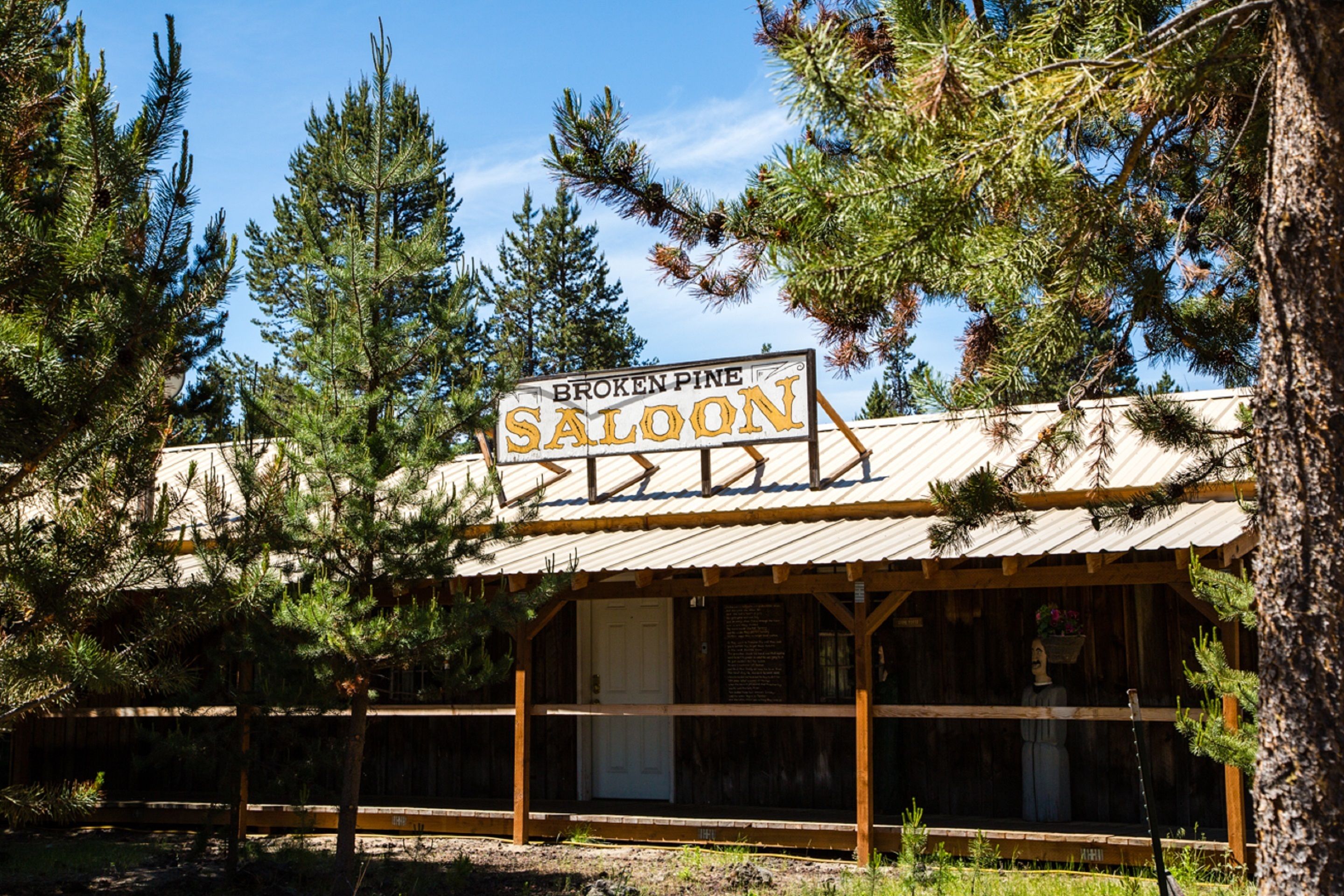 A rustic wooden building with a sign reading "Broken Pine Saloon."