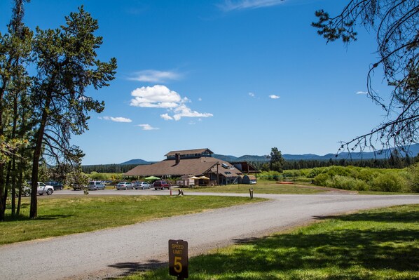 A lodge with a speed limit sign, surrounded by a grassy area and trees.