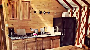 Une cuisine en bois avec une grande table et un réfrigérateur.