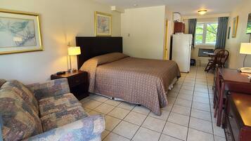 A hotel room with a bed, a sofa, a desk, and a chair.