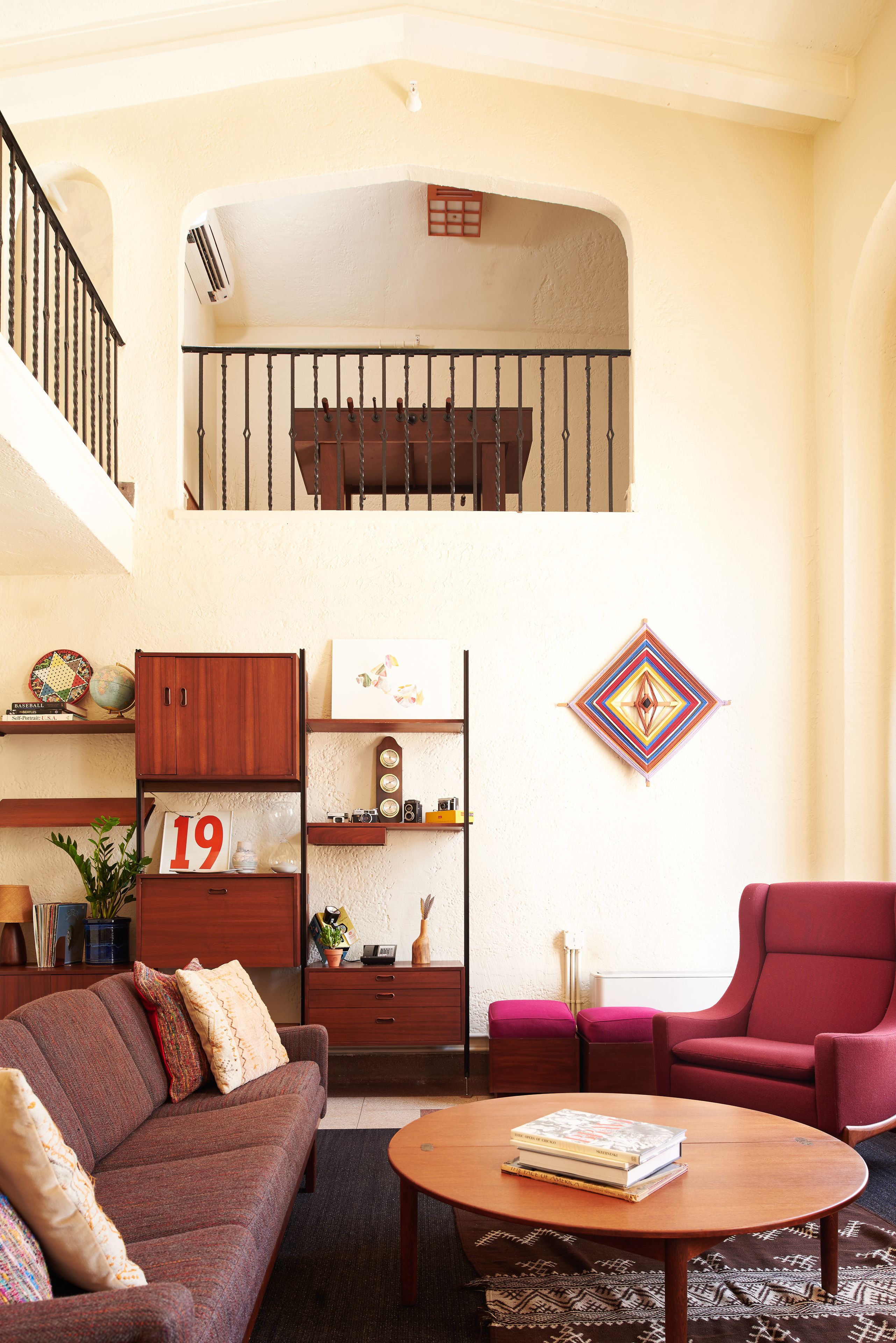 Una sala de estar con sofá, sillón, mesa de centro y estantería.