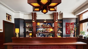 A reception area with a wooden counter, shelves with various items, and a decorative wall hanging.