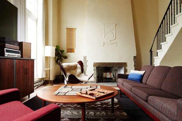 A living room with a fireplace, a sofa, a coffee table, and a TV.