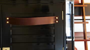 Una porta nera con listelli orizzontali e una tracolla in pelle marrone.