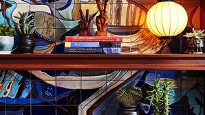 A bookshelf with books, decorative items, and plants.