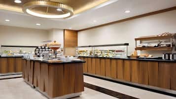 Una cocina moderna con armarios de madera, una isla central y una variedad de alimentos y electrodomésticos.