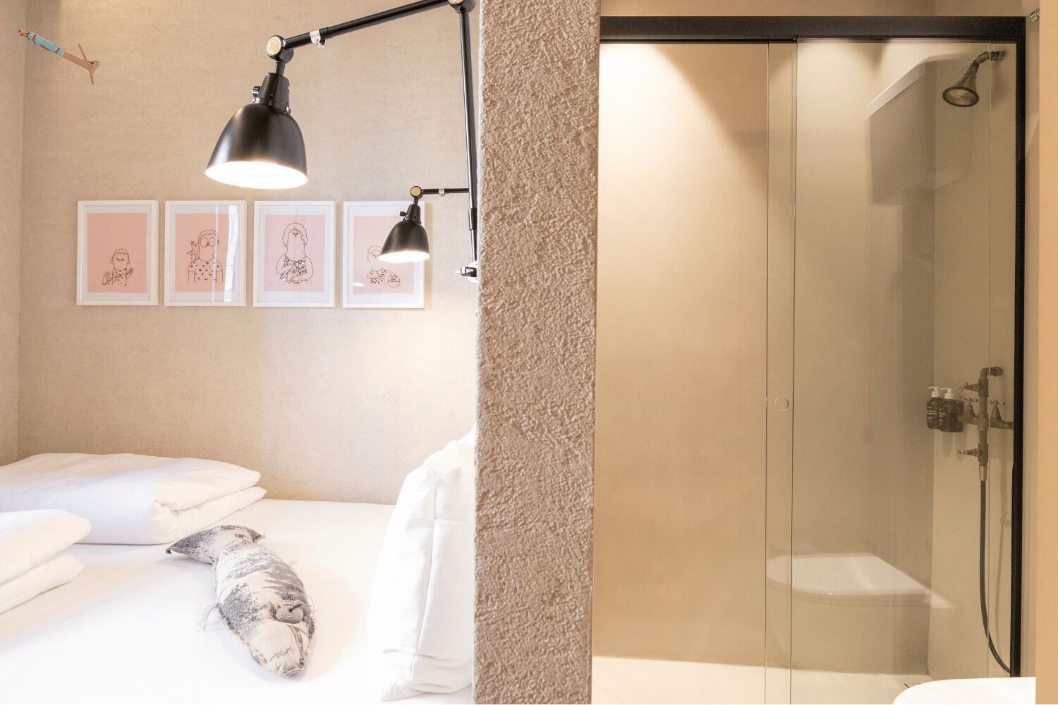 A bedroom with a bed, bedside lamps, a towel, and a pillow.