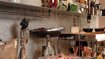 Une cuisine avec des casseroles suspendues, un présentoir à viande et divers ustensiles de cuisine.