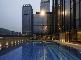 Una piscina al aire libre, sillones reclinables de piscina