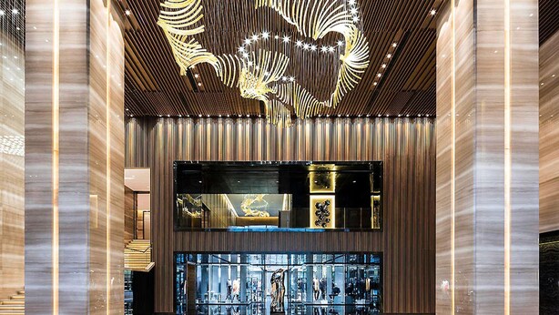 Eine großzügige Lobby im modernen Stil, mit einer imposanten Kristallleuchtre und einer Glastauschiebevitrine.