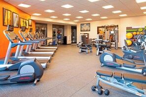 Ein Fitnessstudio mit Laufbändern, Crosstrainern und Gewichten.