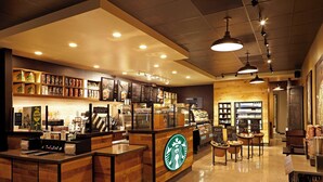 A spacious coffee shop interior with a central counter, wooden accents, and various coffee-related items displayed. - Residence Inn by Marriott Los Angeles LAX/Century Boulevard (Los Angeles)