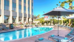 A hotel pool area with lounge chairs and umbrellas, a sign for 'Residence Marriott', and a clear blue sky. - Residence Inn by Marriott Los Angeles LAX/Century Boulevard (Los Angeles)