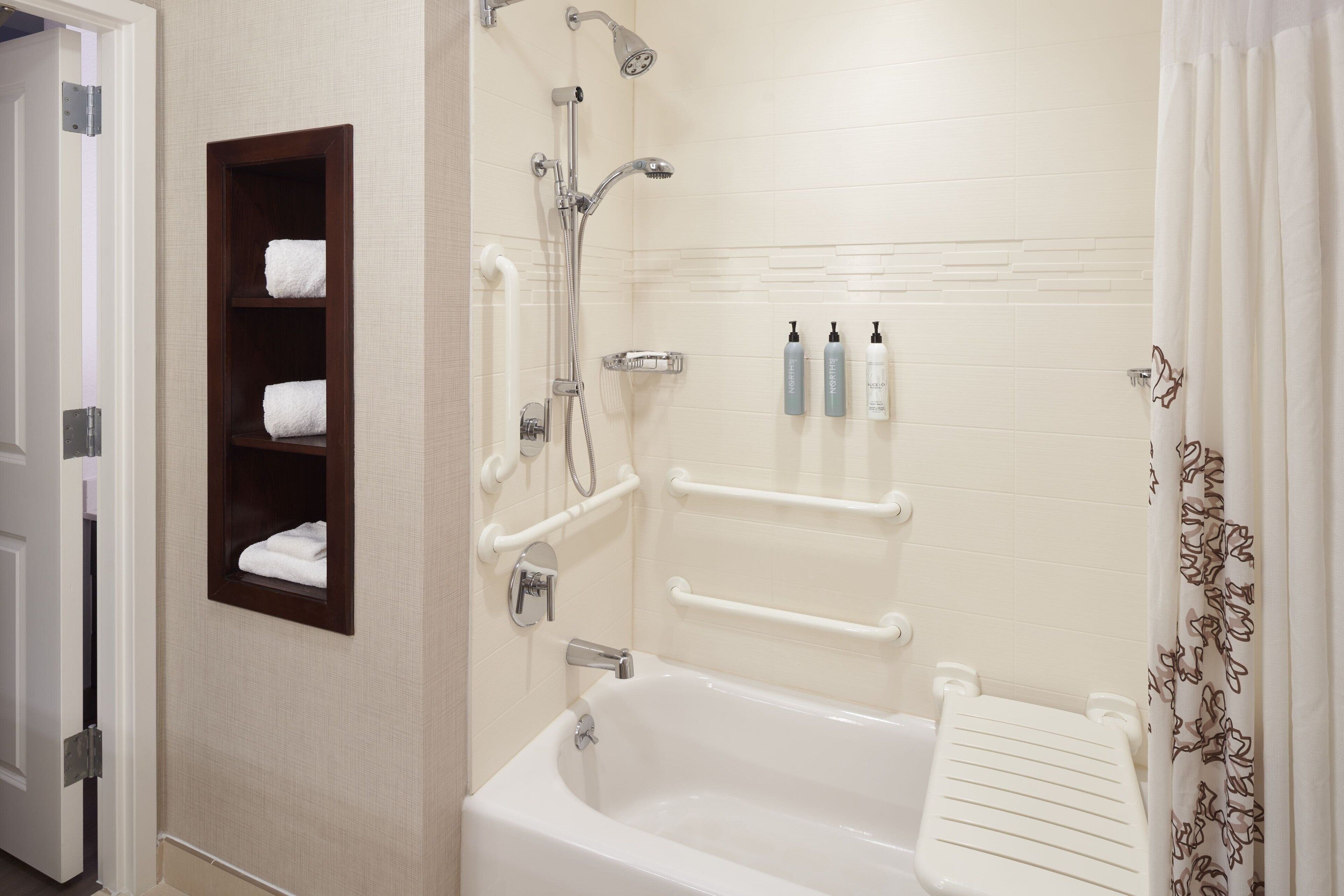 Un bagno con vasca, doccia e porta asciugamani.