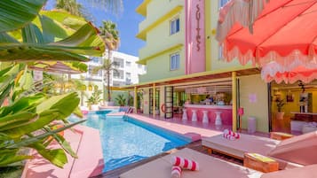 Una piscina al aire libre, sillones reclinables de piscina